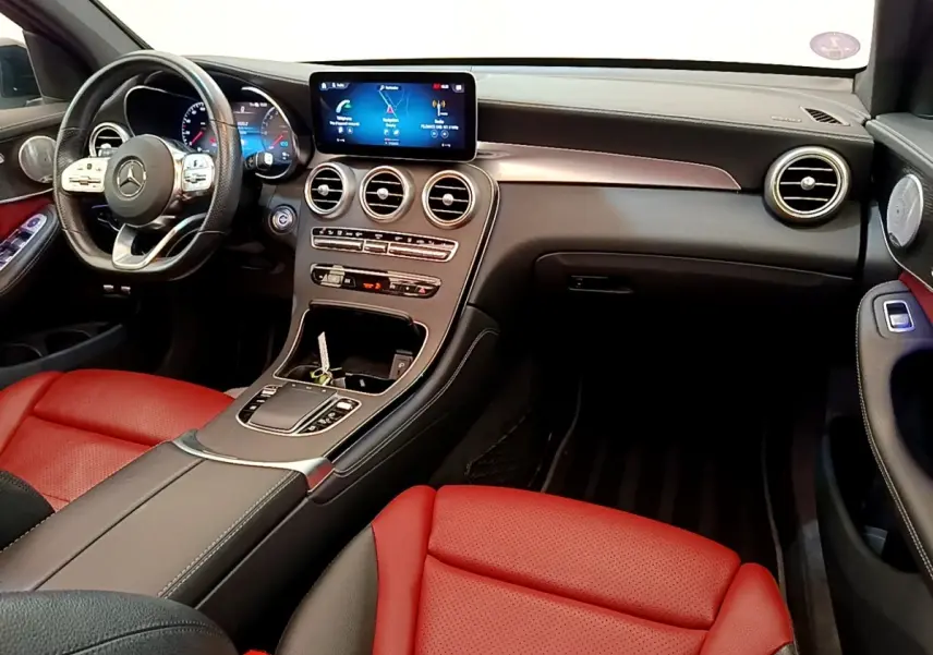 Vue intérieure avant du Mercedes GLC 300 e AMG Line 2020 avec sièges rouges et tableau de bord noir moderne.