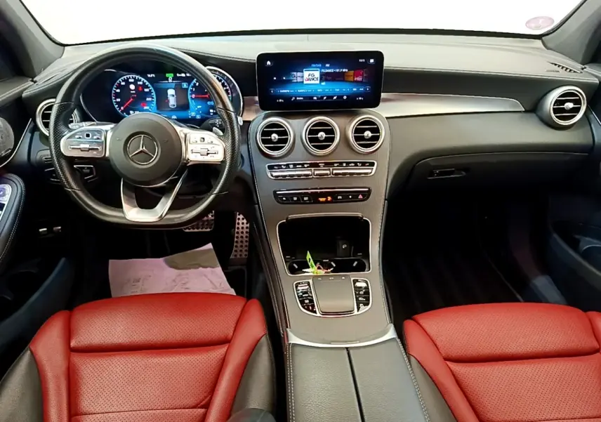 Vue intérieure avant du Mercedes GLC 300 e AMG Line 2020 avec sièges rouges et tableau de bord noir moderne.