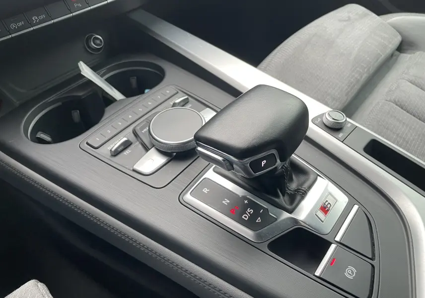 Gros plan sur la console centrale de l'Audi S4 2016, levier de vitesse automatique noir avec logo S et commandes environnantes.