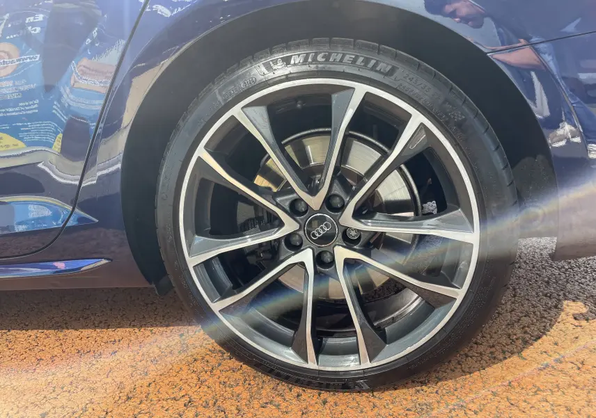 Gros plan sur la roue avant droite d'une Audi S4 bleu Navarre avec jante alliage 19 pouces et pneu Michelin.