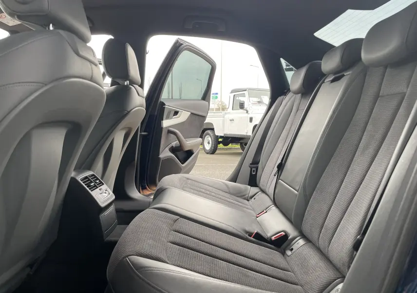 Vue intérieure arrière de l'Audi S4 2016 bleu Navarre, montrant les sièges arrière en cuir et tissu gris avec porte ouverte côté gauche.