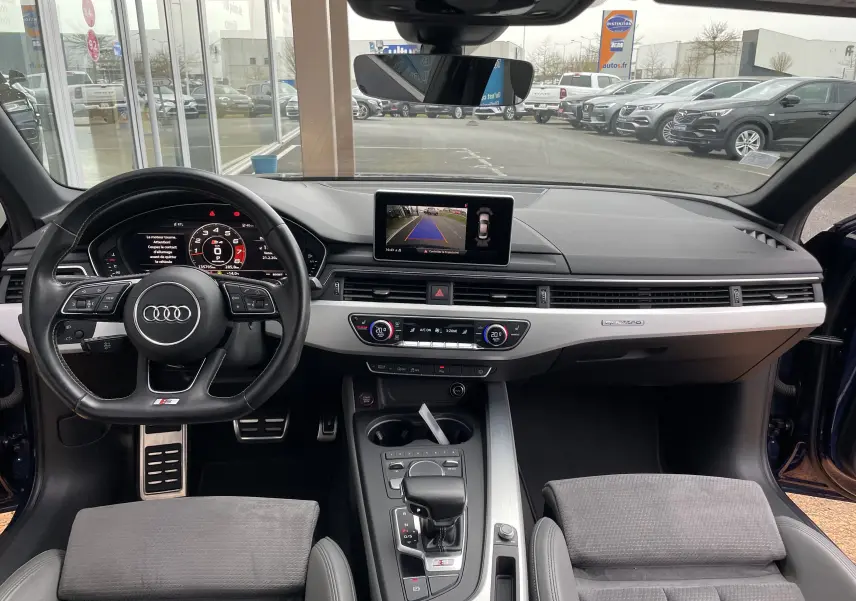 Vue intérieure frontale de l'Audi S4 3.0 V6 TFSI 2016 avec tableau de bord moderne et écran de caméra de recul allumé.
