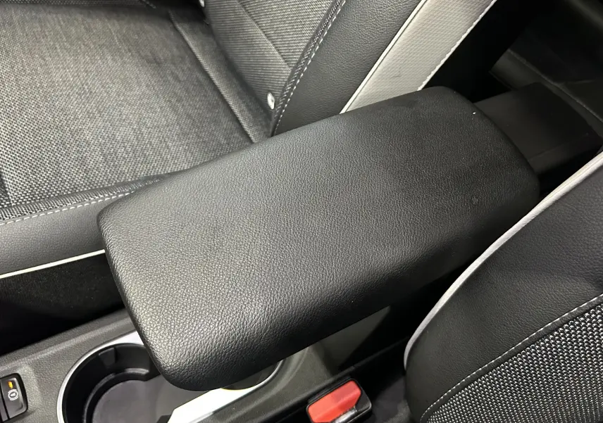 Accoudoir central en cuir noir avec surpiqûres blanches, siège tissu et cuir dans Renault Captur TCE 90CH 2024.