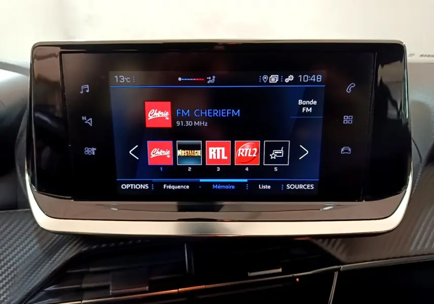 Écran tactile central du tableau de bord du Peugeot 2008 2020 affichant les stations radio FM en mode nuit.