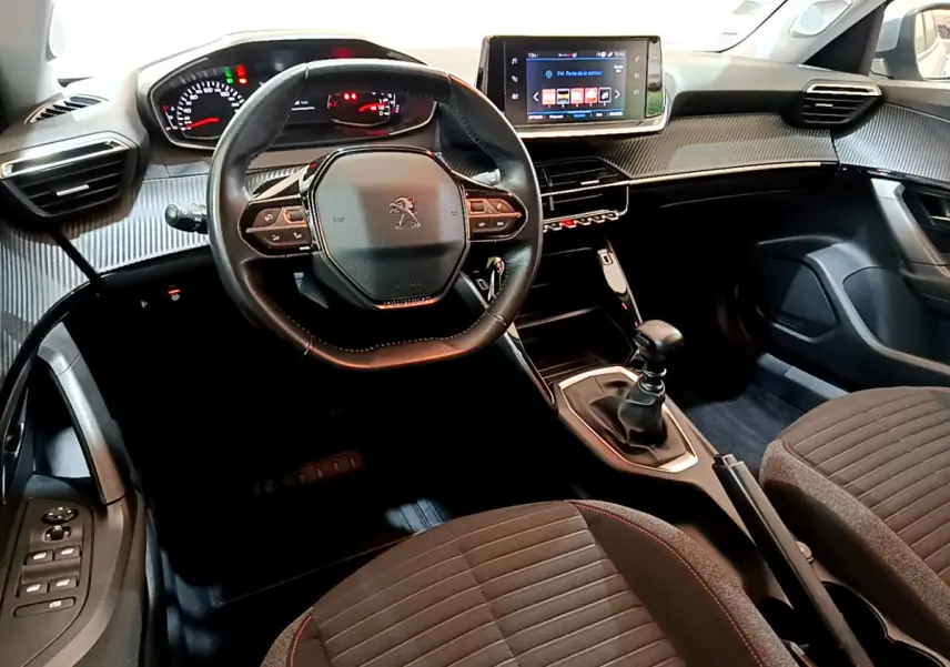 Vue intérieure avant de la Peugeot 2008 2020, volant cuir, tableau de bord avec écran tactile et levier de vitesse manuel.