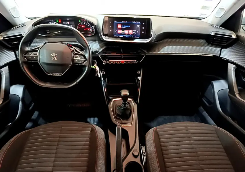 Intérieur Peugeot 2008 2020 vu de face, tableau de bord noir avec écran tactile et volant cuir multifonctions.