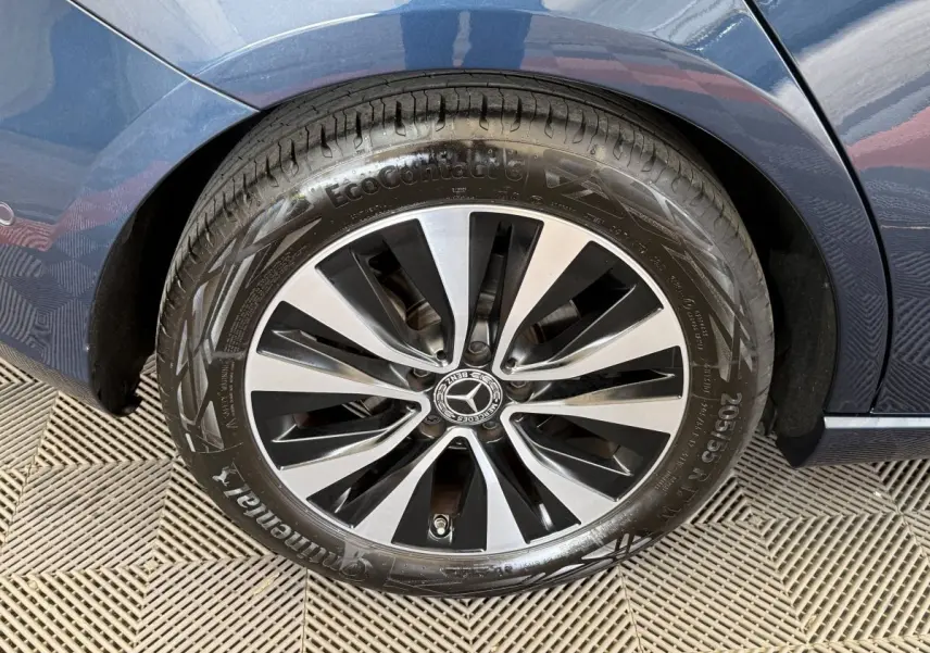 Gros plan sur la roue arrière droite d’une Mercedes Classe A bleu 2021 avec jante alliage bicolore et pneu Continental.
