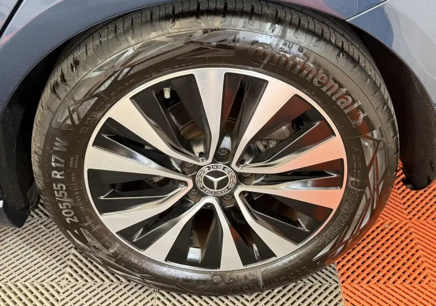 Gros plan sur la roue avant droite d’une Mercedes Classe A 180 d Business Line bleu, jante alliage bicolore.