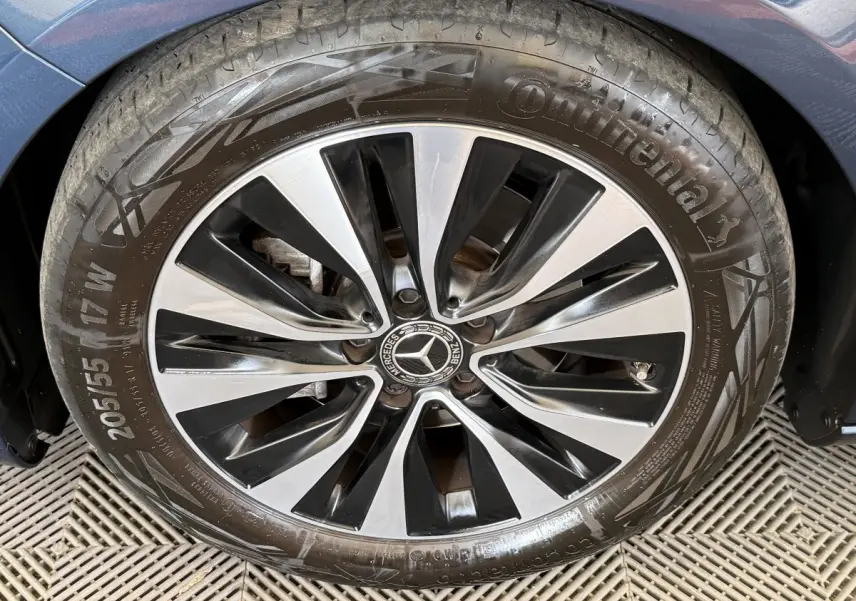 Gros plan sur la roue avant droite d’une Mercedes Classe A bleu, avec jante alliage bicolore et logo central Mercedes.