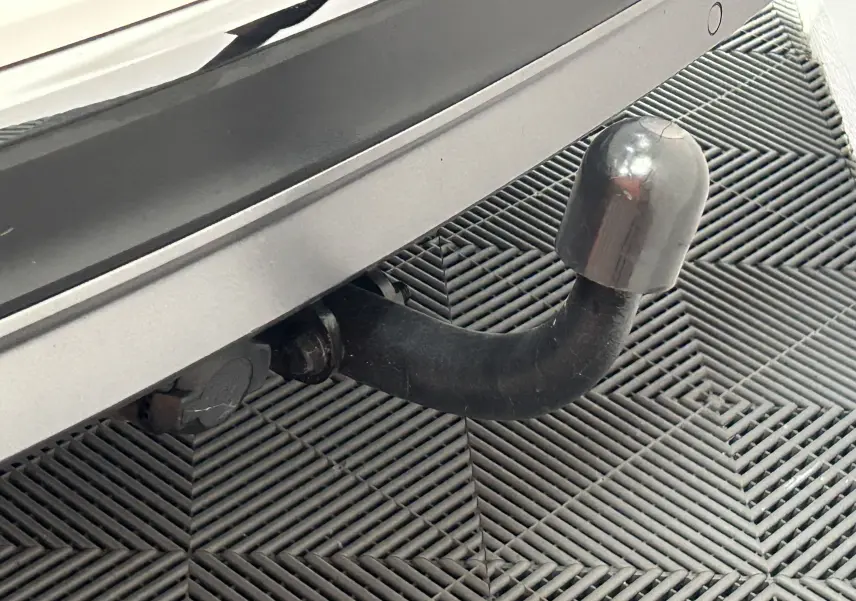 Gros plan sur l'attelage noir fixé à l'arrière blanc du Volkswagen Tiguan Allspace 2018, sur sol en damier.