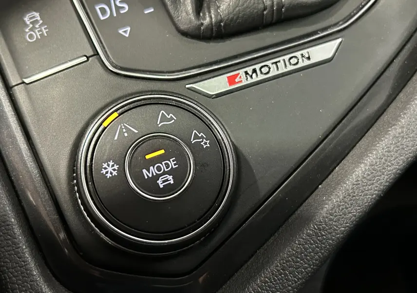 Gros plan sur la molette de sélection de mode 4Motion du Volkswagen Tiguan Allspace blanc, avec icônes de terrain visibles.