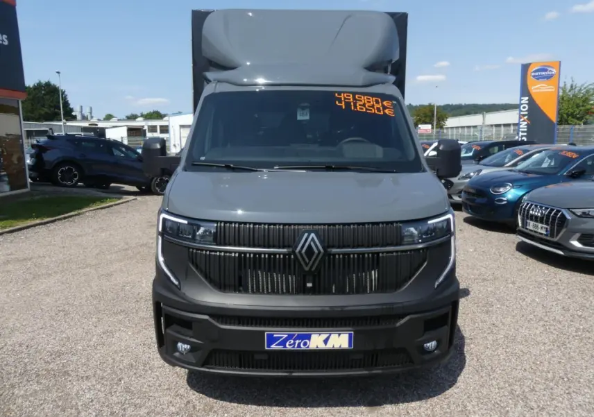 Vue avant d'un Renault Master Extra gris avec calandre noire et prix affiché sur le pare-brise.