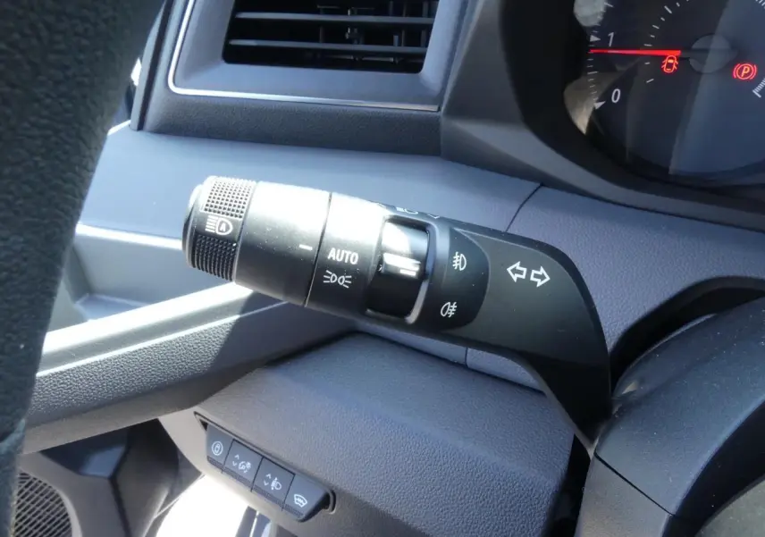 Gros plan sur la commande des feux et clignotants côté gauche du tableau de bord gris du Renault Master 2025.