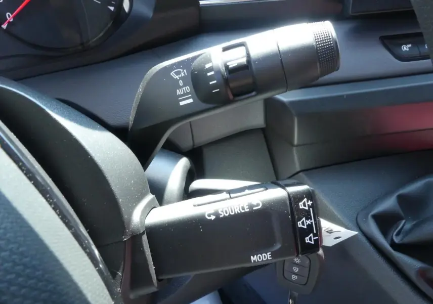 Gros plan sur les commandes au volant du Renault Master gris, montrant les boutons source et mode côté conducteur.