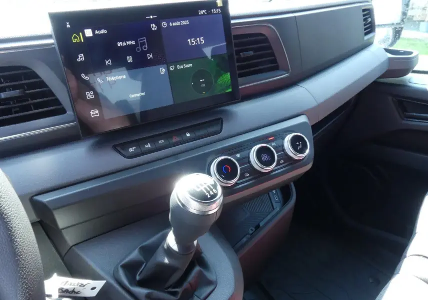 Vue intérieure du tableau de bord du Renault Master Extra 2025 avec levier de vitesse manuel et écran tactile central.