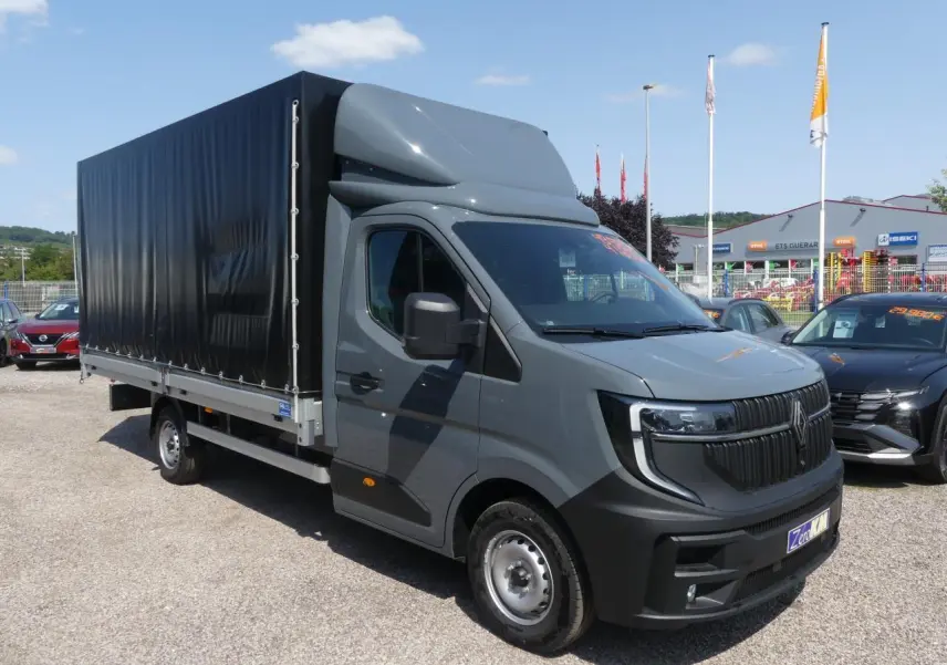 Renault Master Extra gris vu en 3/4 avant droit avec bâche noire et calandre verticale distinctive.