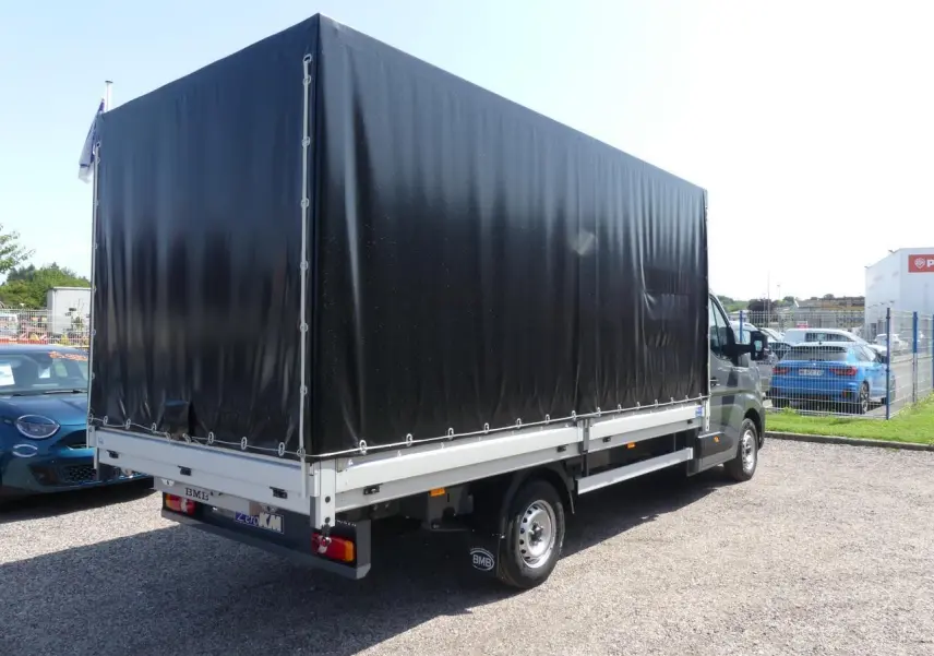 Renault Master Extra 2025 gris, vue 3/4 arrière droit avec bâche noire couvrant la zone de chargement.