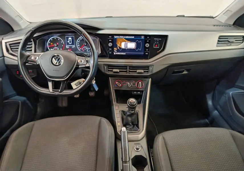 Intérieur Volkswagen Polo 2020 vue avant du tableau de bord avec volant cuir, écran tactile et levier de vitesse manuel.