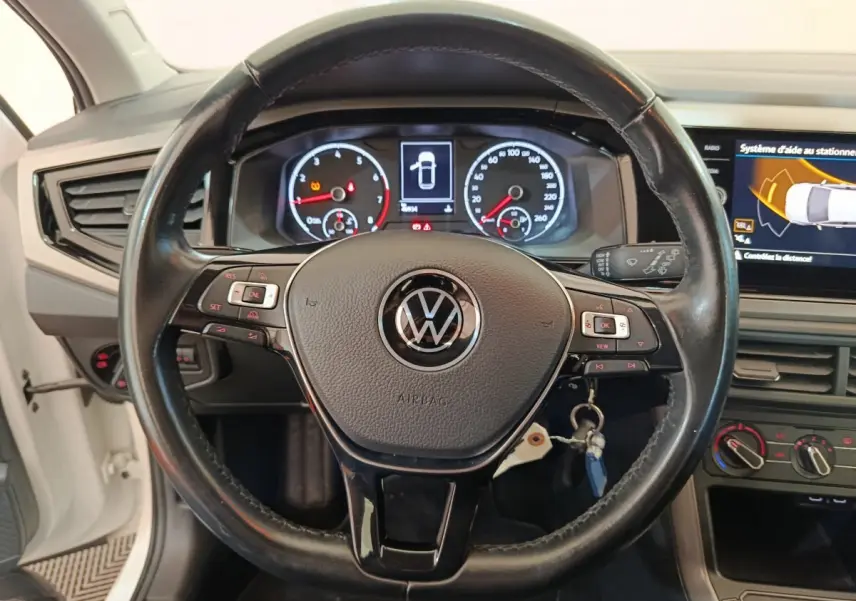 Vue rapprochée du volant cuir et alu Volkswagen Polo 2020 avec tableau de bord numérique et écran tactile latéral.