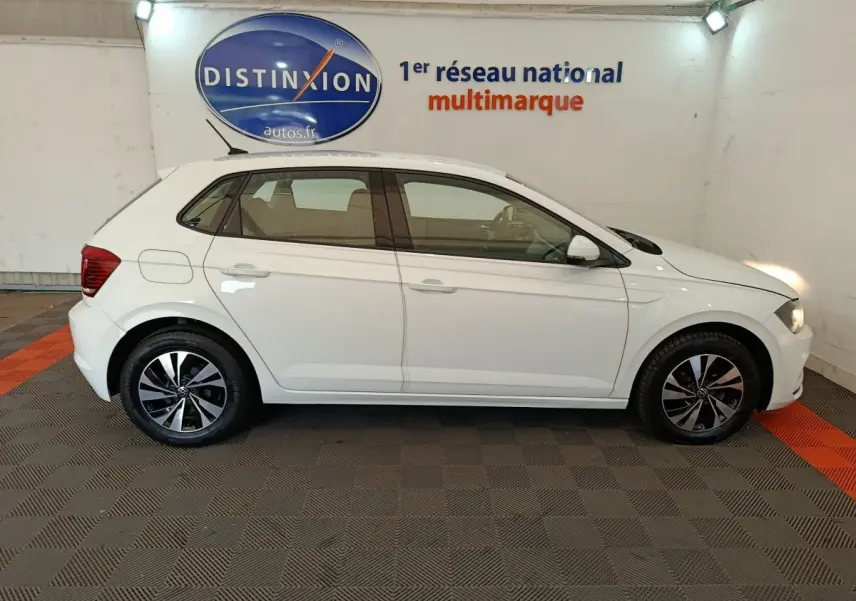 Profil droit d'une Volkswagen Polo blanche 2020 avec jantes alliage et logo Distinxion en arrière-plan.