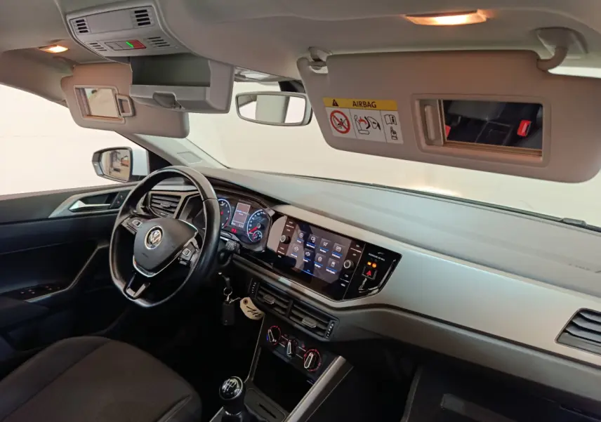 Intérieur avant droit d'une Volkswagen Polo blanche 2020, tableau de bord avec écran tactile et volant cuir multifonctions.
