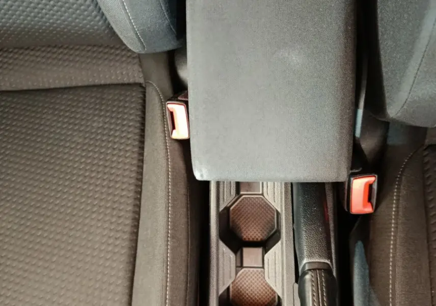 Vue plongeante sur la console centrale noire et les sièges tissu gris foncé de la Volkswagen Polo 1.0 TSI 95 Lounge Business blanche.