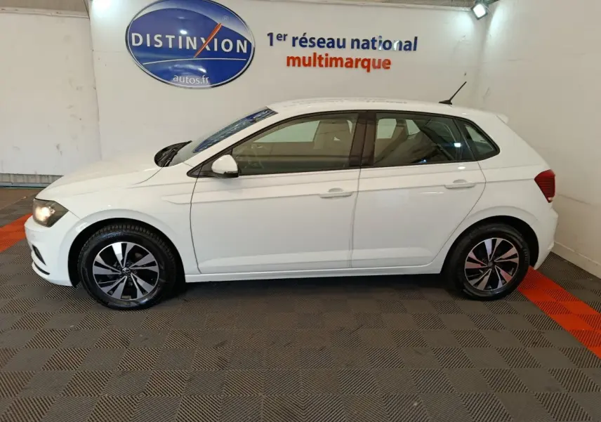 Profil côté gauche d'une Volkswagen Polo blanche 2020 stationnée en intérieur avec jantes alliage bicolores.