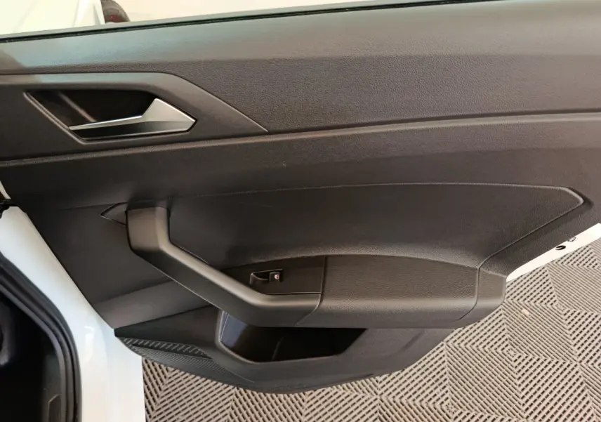 Vue rapprochée de la porte avant gauche noire d'une Volkswagen Polo blanche 2020, avec poignée intégrée.