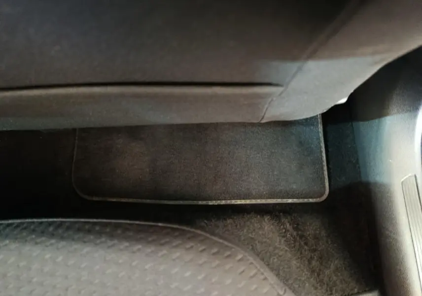 Gros plan sur le tapis de sol noir côté passager avant d'une Volkswagen Polo blanche 2020.