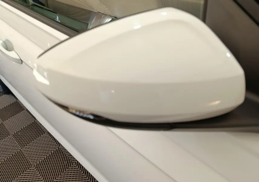 Gros plan sur le rétroviseur droit blanc d'une Volkswagen Polo 2020, avec clignotant intégré visible.