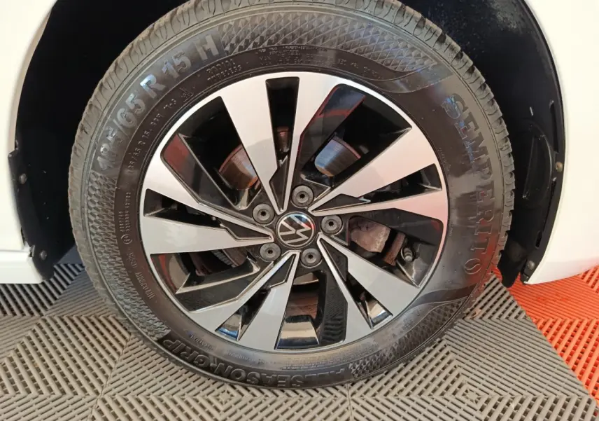 Gros plan sur la roue avant droite d'une Volkswagen Polo blanche, avec jante alliage noir et argentée design moderne.
