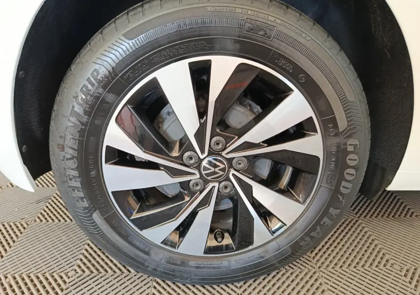 Gros plan sur la roue avant droite d'une Volkswagen Polo blanche, jante alliage bicolore noir et argent.