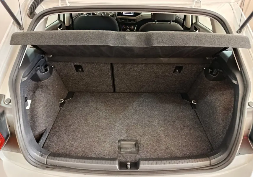 Coffre ouvert vu de l'arrière d'une Volkswagen Polo blanche 2020, montrant l'espace de chargement et la tablette cache-bagages.