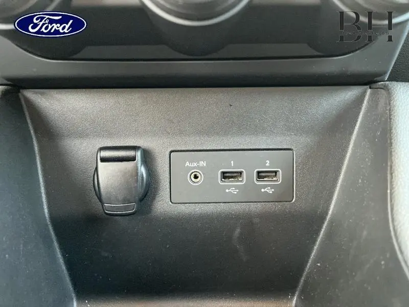 Prise auxiliaire et deux ports USB noirs sur la console centrale d'une Renault Clio Gris Platine vue de face.