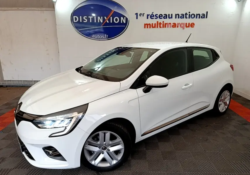 Renault Clio Business Blue dCi 85 blanche vue 3/4 avant droit avec phares LED allumés en intérieur showroom.