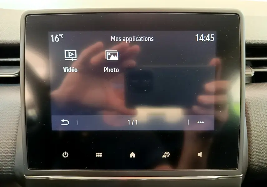 Écran tactile central allumé du tableau de bord de la Renault Clio Business Blue dCi 85, affichage des applications vidéo et photo.