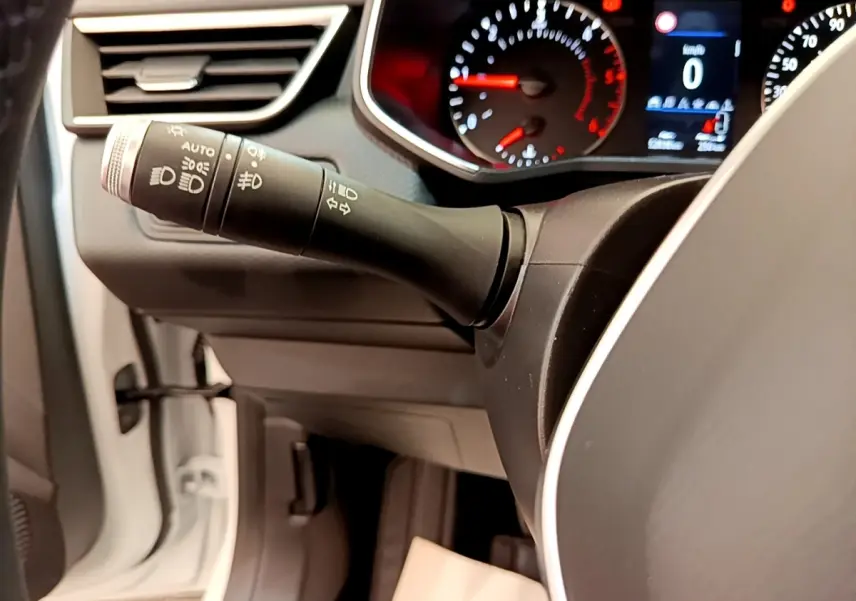 Gros plan sur le commodo gauche et le tableau de bord numérique de la Renault Clio Business Blue dCi 85 blanche de 2020.