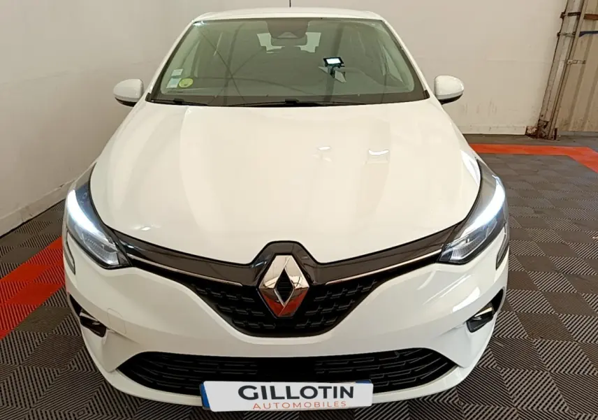 Vue avant d'une Renault Clio Business Blue dCi 85 blanche avec phares LED allumés dans un garage.