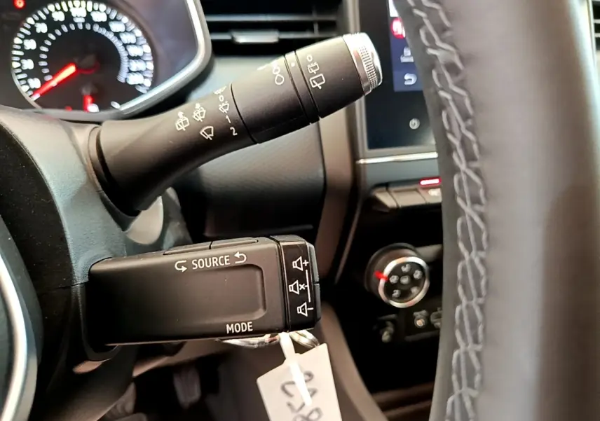 Gros plan sur le volant et commandes au volant de la Renault Clio Business Blue dCi 85, tableau de bord partiellement visible.