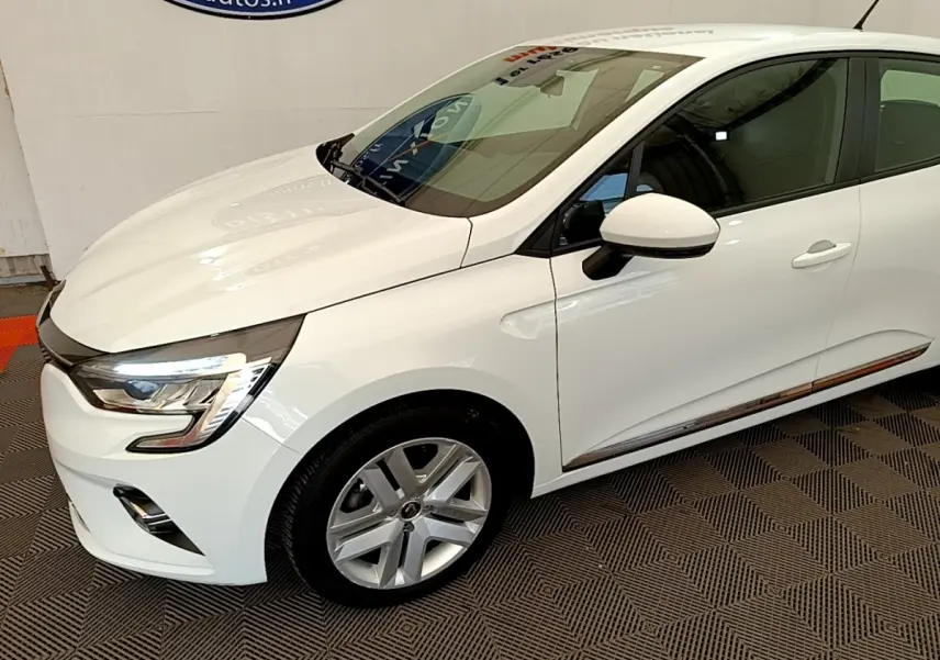 Vue 3/4 avant droite d'une Renault Clio Business Blue dCi 85 blanche avec jantes alliage et rétroviseurs blancs.