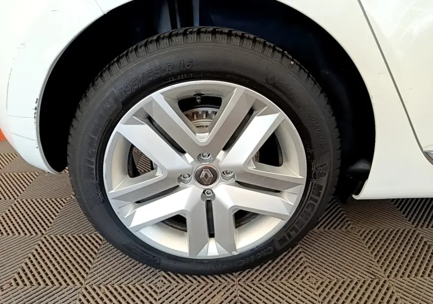 Gros plan sur la roue avant droite blanche d'une Renault Clio Business Blue dCi 85 avec jante alliage argentée.