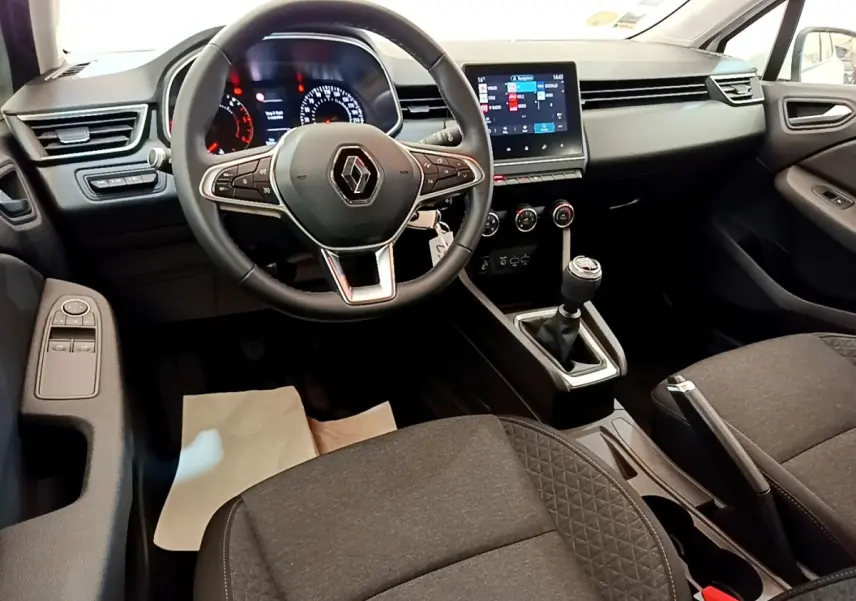 Vue intérieure avant de la Renault Clio Business Blue dCi 85 2020, volant cuir, tableau de bord avec écran tactile et boîte manuelle.