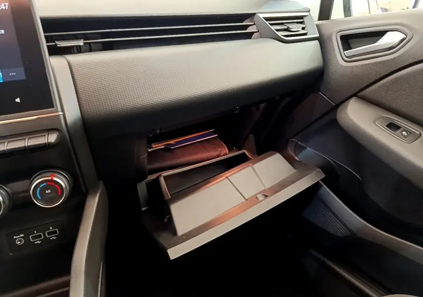 Vue intérieure côté passager de la Renault Clio Business Blue dCi 85 2020, boîte à gants ouverte et tableau de bord noir.