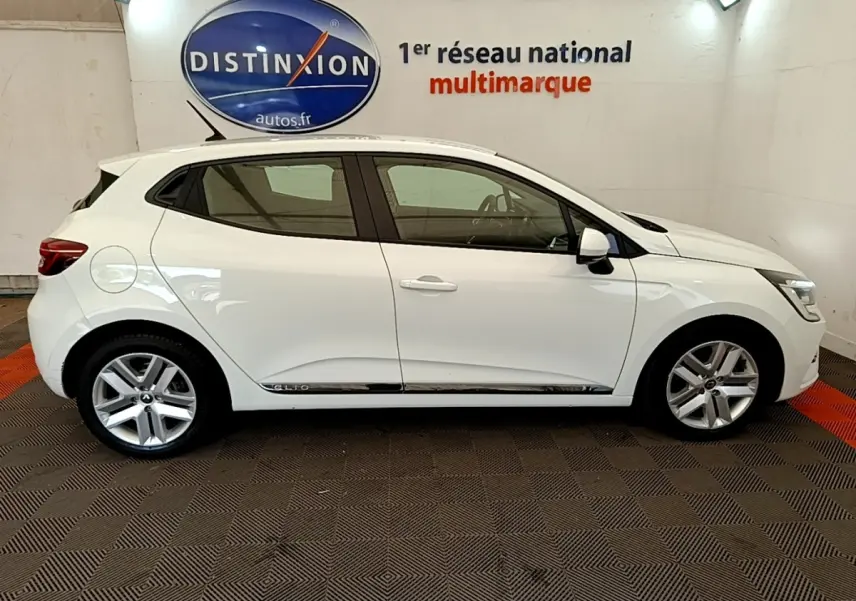 Profil droit d'une Renault Clio blanche 2020 Business Blue dCi, avec jantes alliage et logo Distinxion en arrière-plan.
