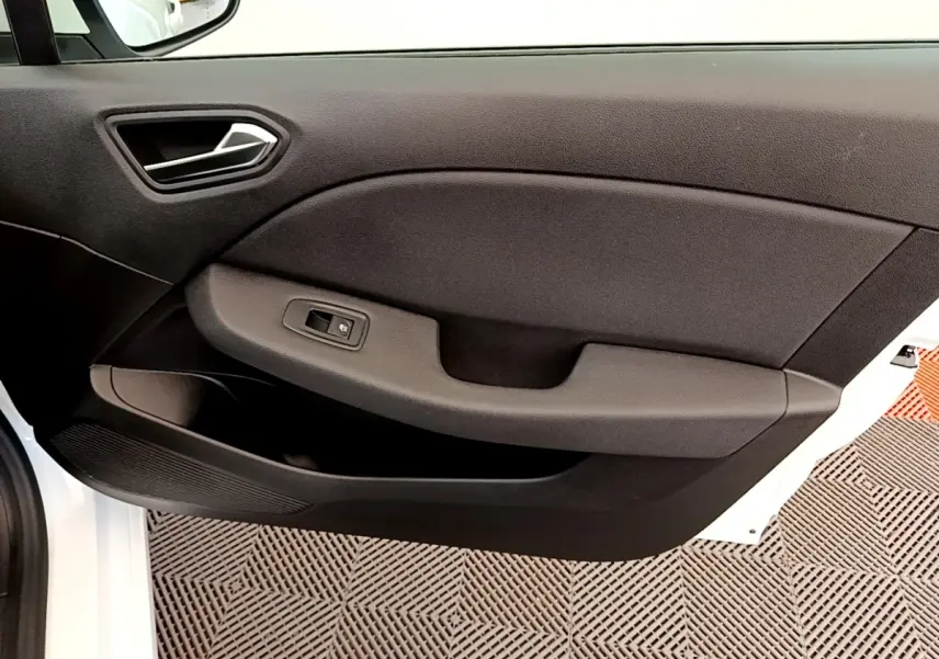 Vue intérieure de la porte avant gauche d'une Renault Clio Business Blue dCi 85 blanche, avec poignée et commande de vitre noire.