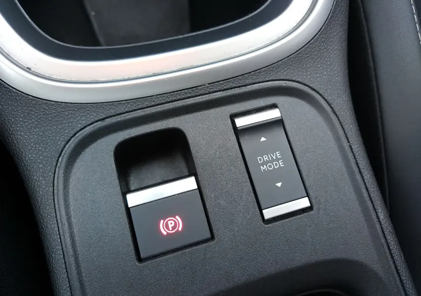 Gros plan sur la console centrale noire du Jeep Avenger eHYBRID avec bouton frein à main électronique et sélection mode de conduite.