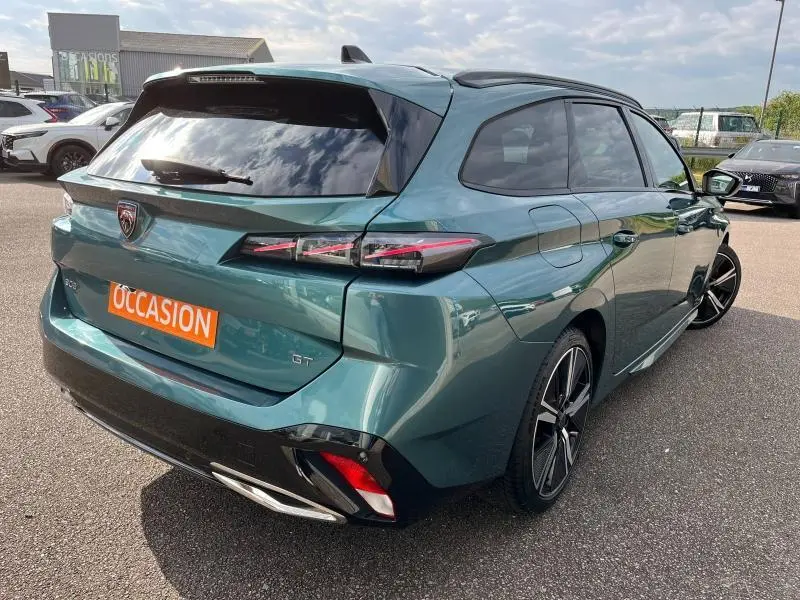 Vue 3/4 arrière droite d'une Peugeot 308 SW GT Bleu Avatar métallisé avec feux arrière LED et jantes alliage 18 pouces.