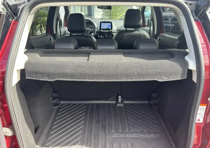 Coffre ouvert d'un Ford EcoSport rouge 2019, vue arrière montrant l'intérieur et l'écran tactile du tableau de bord.