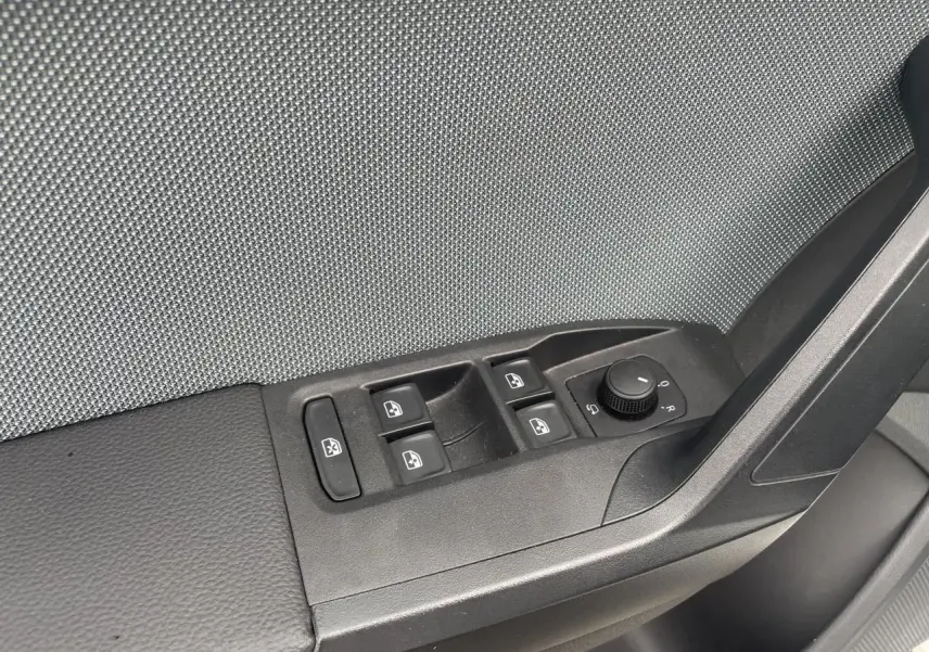 Panneau de porte côté gauche avec commandes des vitres et réglage des rétroviseurs d'une SEAT IBIZA blanche 2025.