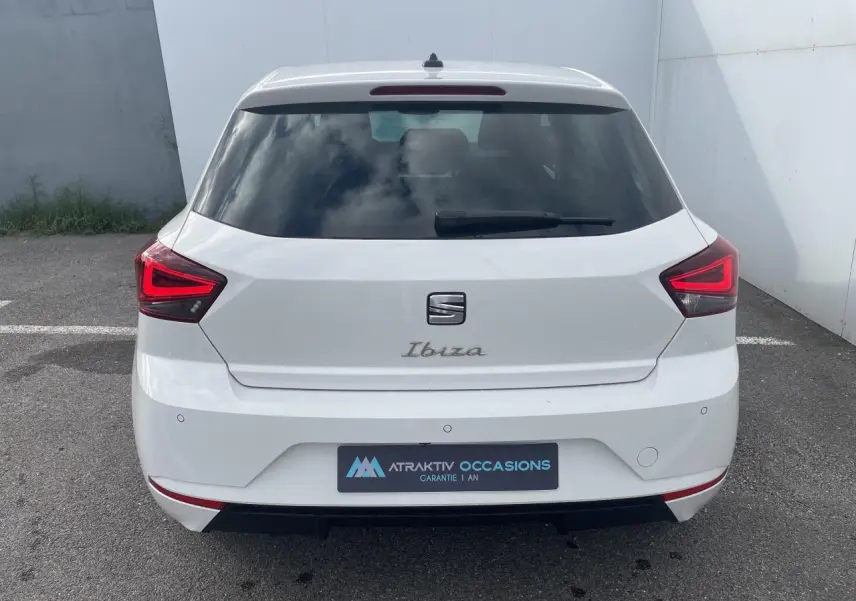 Vue arrière d'une SEAT Ibiza blanche avec feux arrière LED en forme de triangle et lunette arrière teintée.